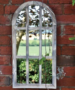 vintage style garden mirror on a red brick wall