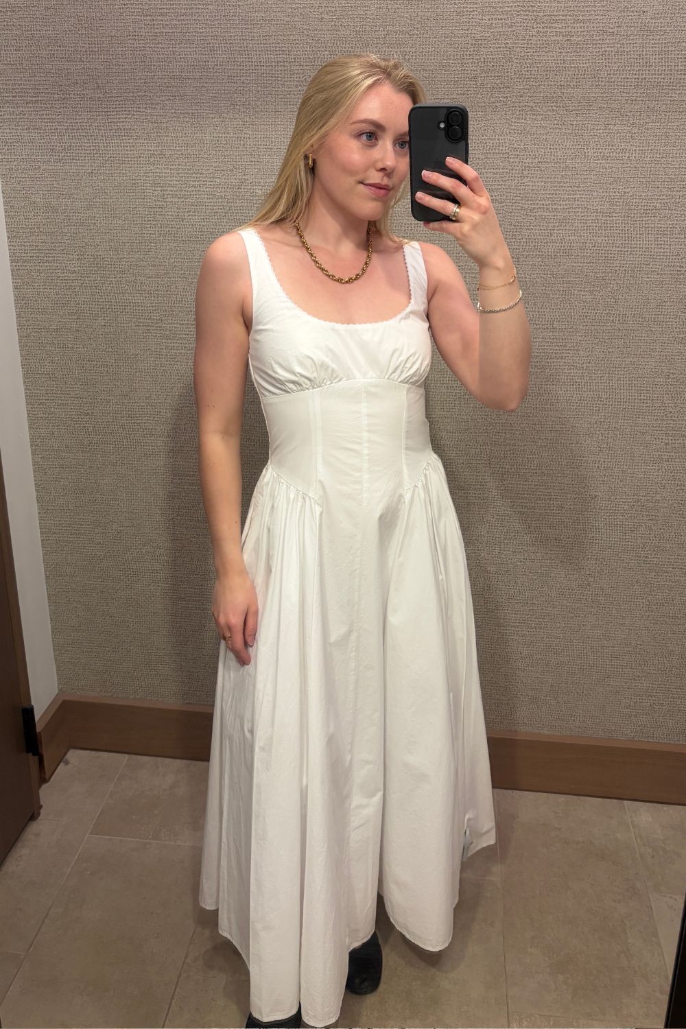 Woman wears white basque waist dress from Abercrombie