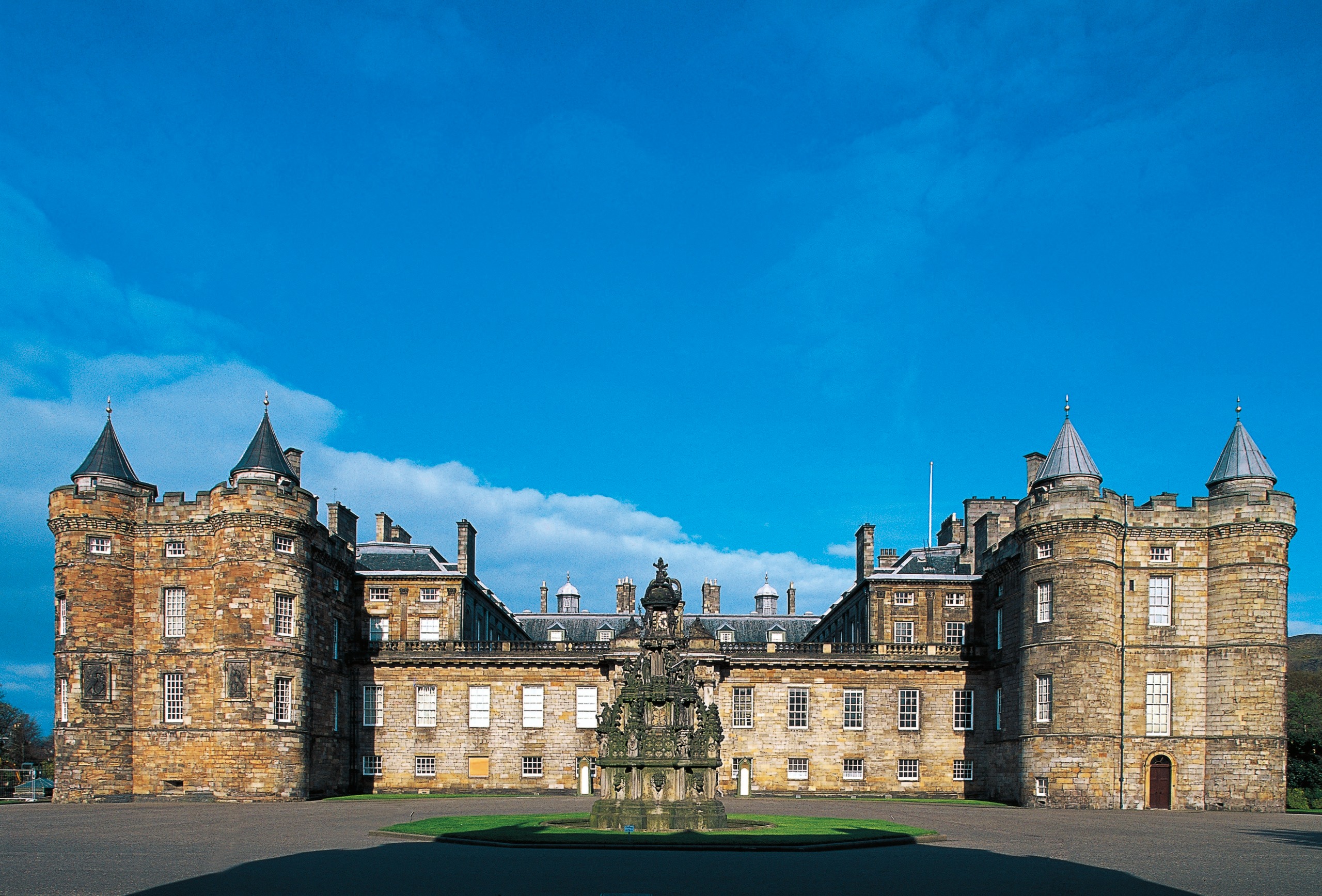 An exterior shot of the Palace of Holyroodhouse against a blue sky