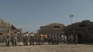 24 women covered in mud stand in an outdoor arena, in the netflix show 'siren survive the island'