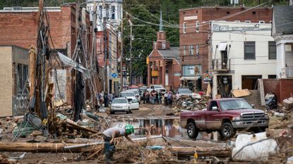 Workers, community members, and business owners clean up debris in the aftermath of Hurricane Helene in Marshall, North Carolina on Monday, Sept. 30, 2024.