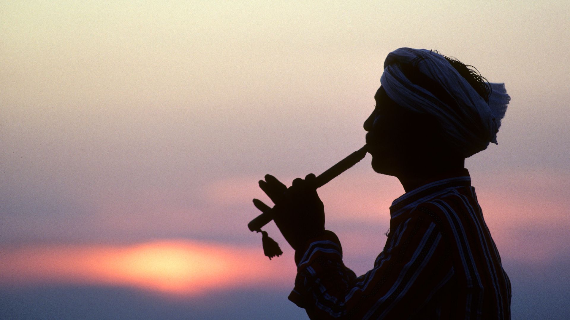 man playing The bansuri in india