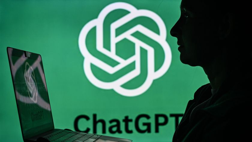 An image of a woman holding a laptop in front of a ChatGPT logo displayed on a computer screen.