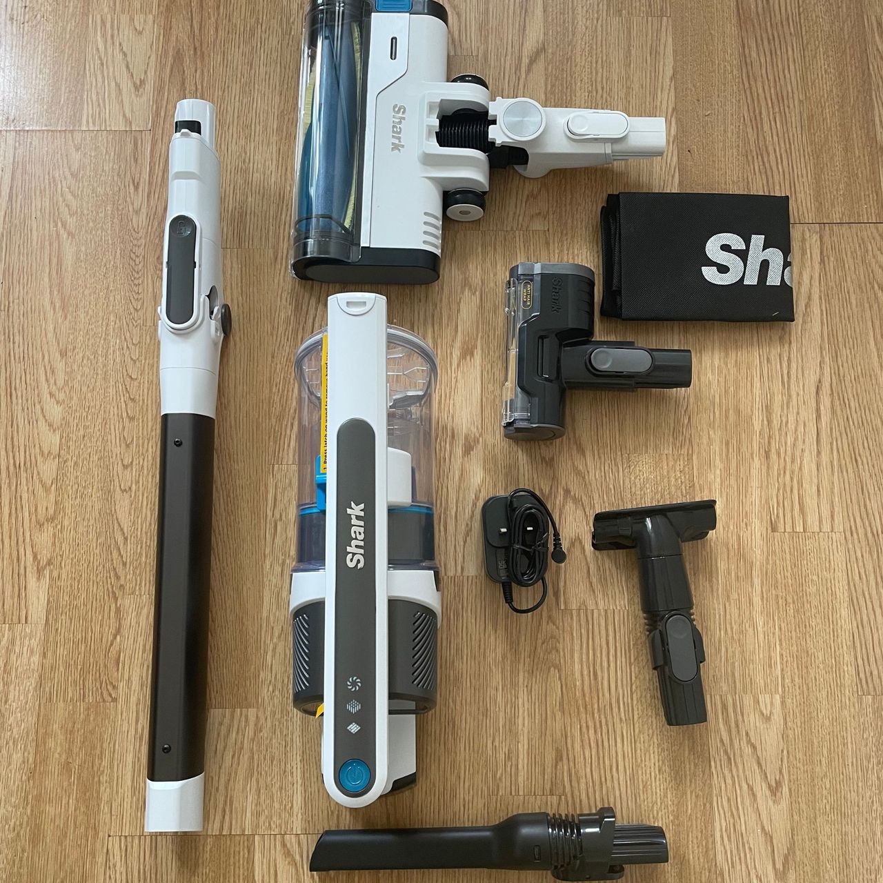 Shark PowerPro Pet Cordless Stick Vacuum components laid out on laminate floor