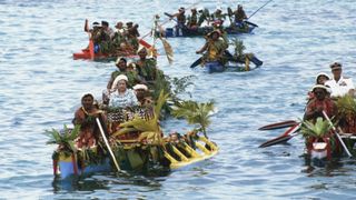 Queen Elizabeth II and Prince Philip, Duke of Edinburgh are bought ashore from HMY Britannia by a fleet of local canoes to the shore of Funafuti in Tuvalu on October 26, 1982 during the Royal Tour of the South Pacific.