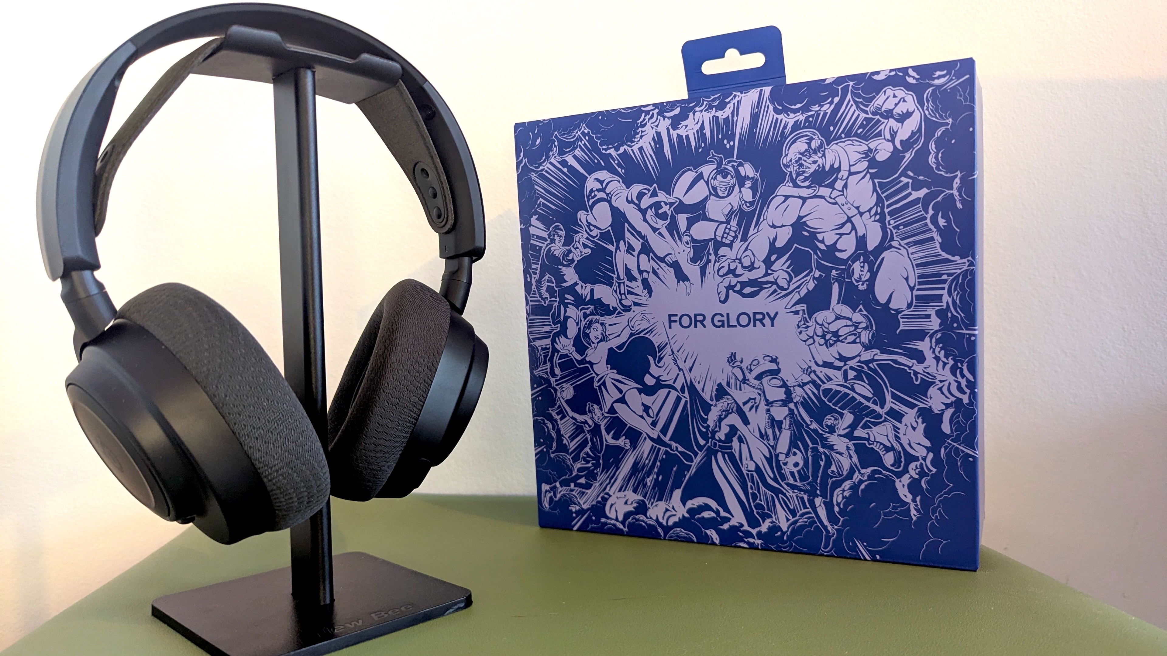 Black headphones on a black stand, on a green surface