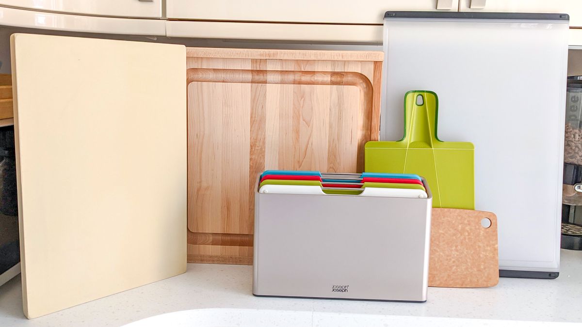 A selection of cutting boards stacked in a kitchen 