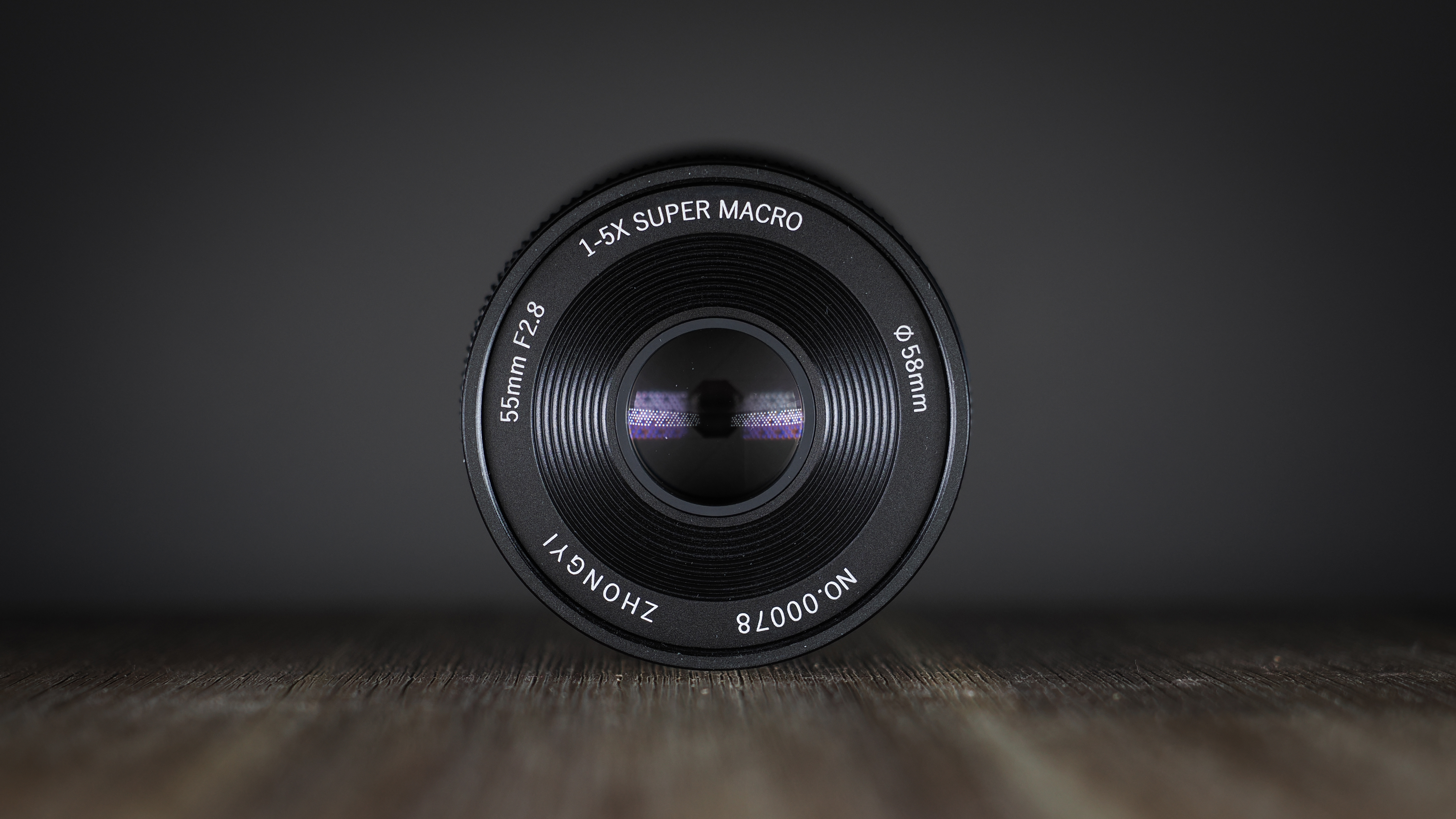 Mitakon 55mm f/2.8 1-5x Macro on a wooden surface