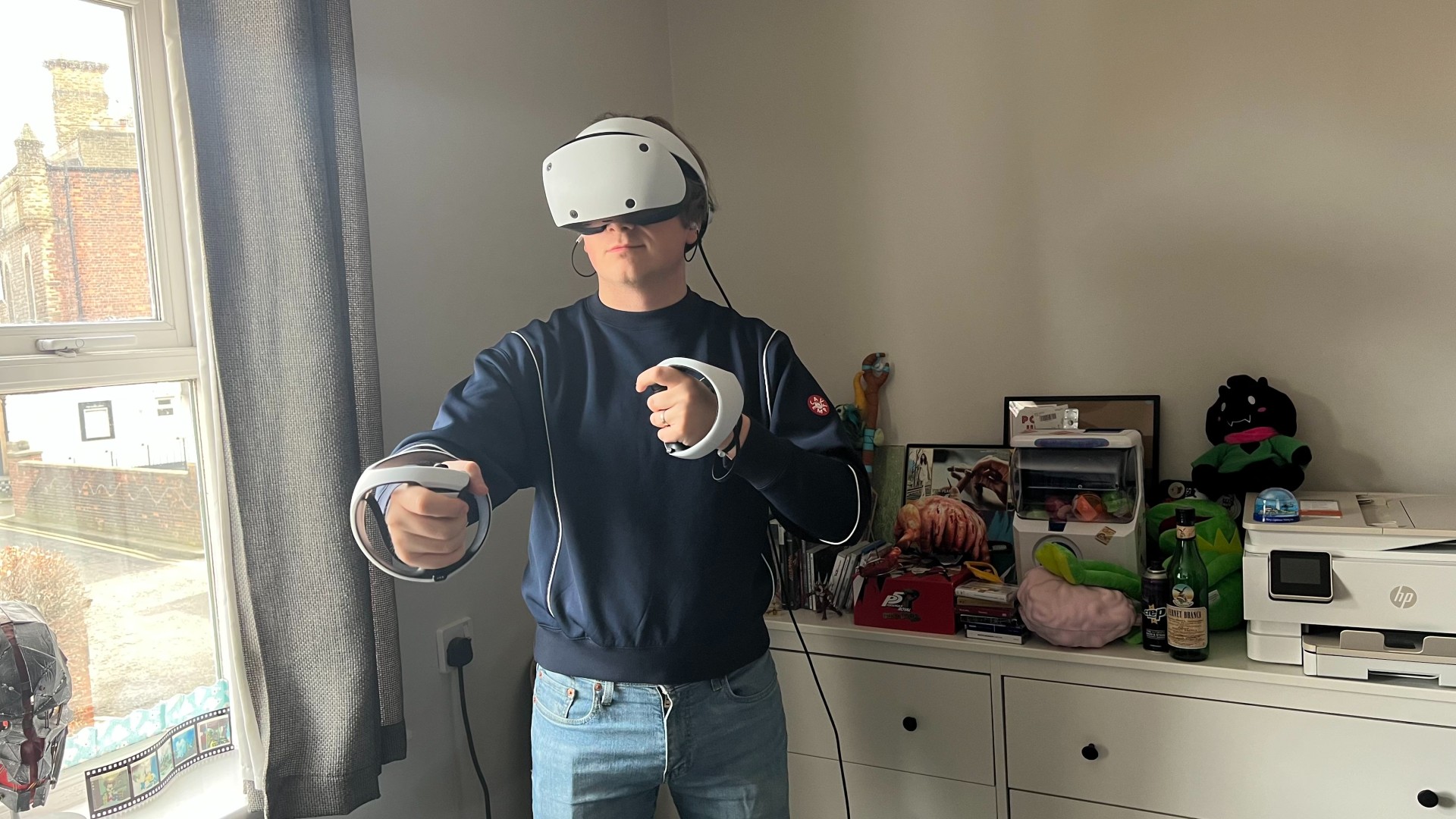 PSVR2- Man using virtual reality headset and controllers.