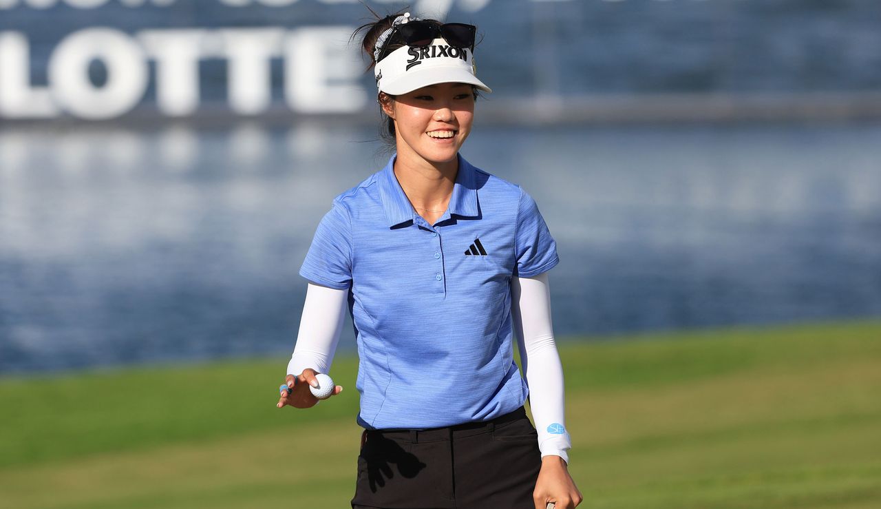 Kim waves to the crowd after holing her putt on the 18th green