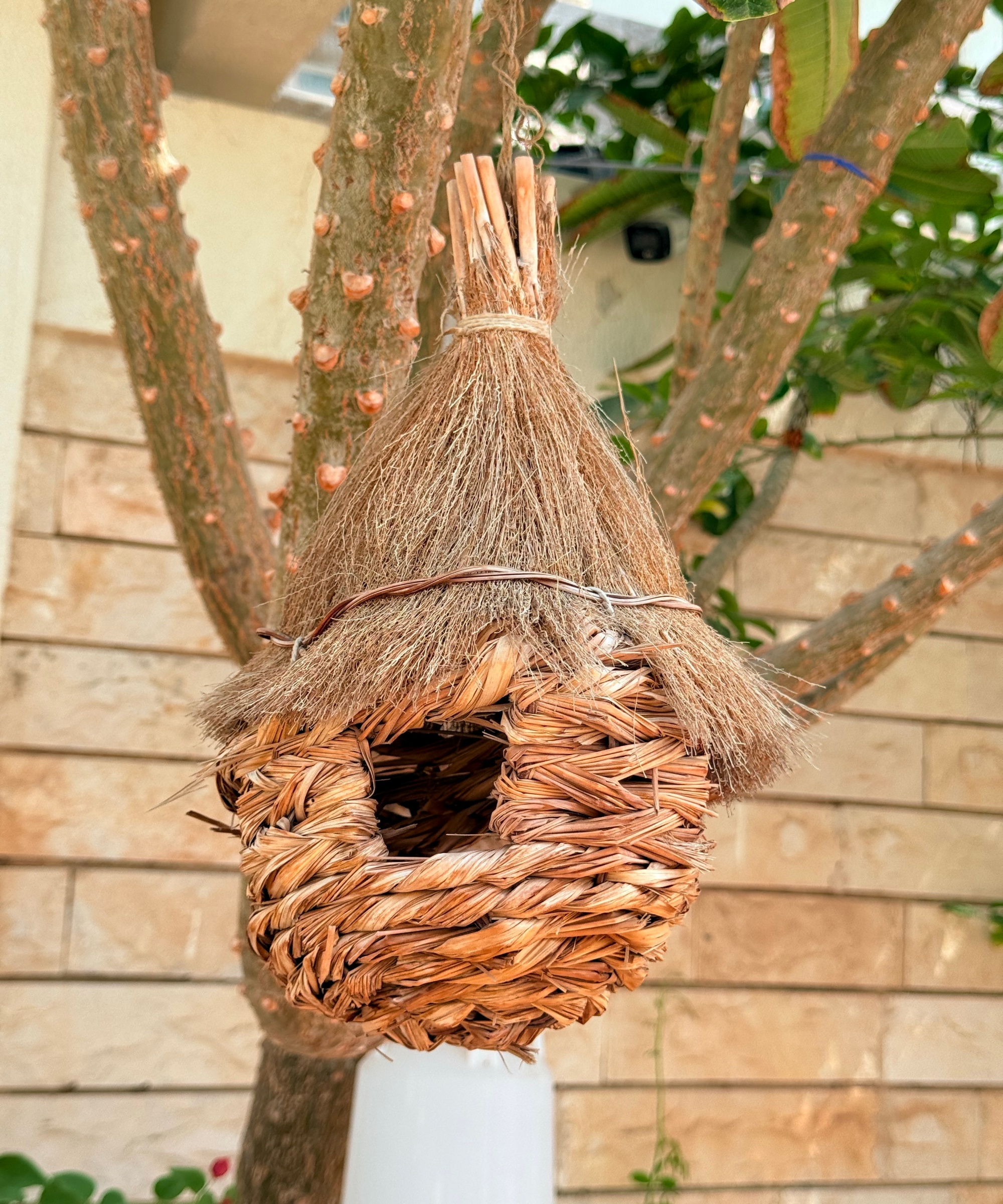 A bird shelter made from a woven hanging basket
