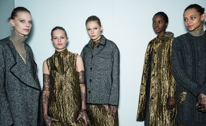 four female models wearing grey and gold knit coats