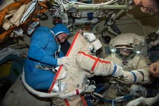 Russian cosmonauts Fyodor Yurchikhin (left) and Alexander Misurkin practice donning their spacesuits for a June 24, 2013 spacewalk outside the International Space Station. They will venture outside the station again on Aug. 16 and Aug. 22.
