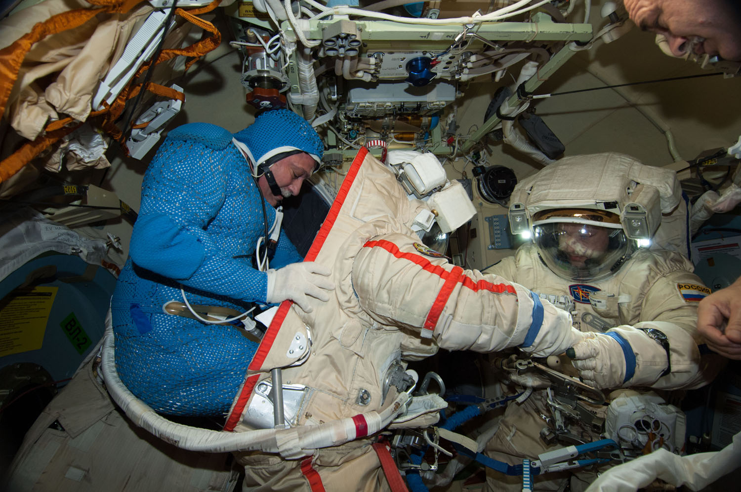 Russian cosmonauts Fyodor Yurchikhin (left) and Alexander Misurkin practice donning their spacesuits for a June 24, 2013 spacewalk outside the International Space Station. They will venture outside the station again on Aug. 16 and Aug. 22.