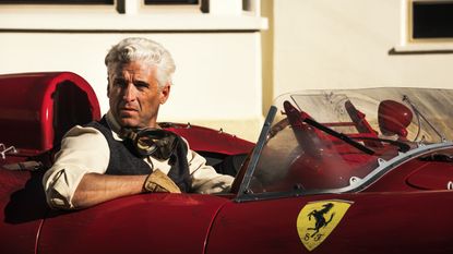 Patrick Dempsey sits in a Ferrari on the set of Ferrari: The Movie