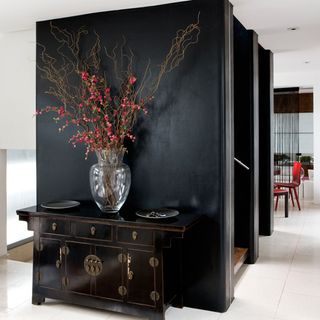 hallway with black cabinet and white walls