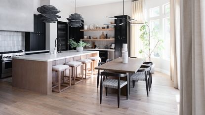 sticking to budget, open plan kitchen with dining area, white countertops, statement pendant lights, open shelving, black cabinetry 