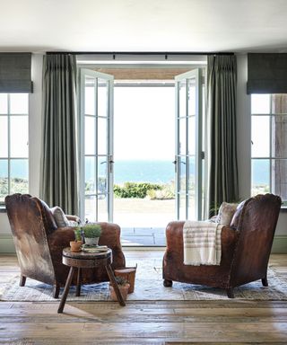 Seating area with sea view and leather armchairs in Cornish coastal newbuild