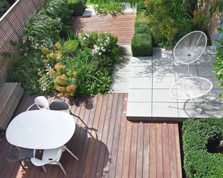 a garden patio in a sleek, modern scheme with squares of decking and stone patio overlapping.