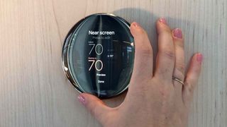 Person's hand adjusting Google Nest Learning Thermostat