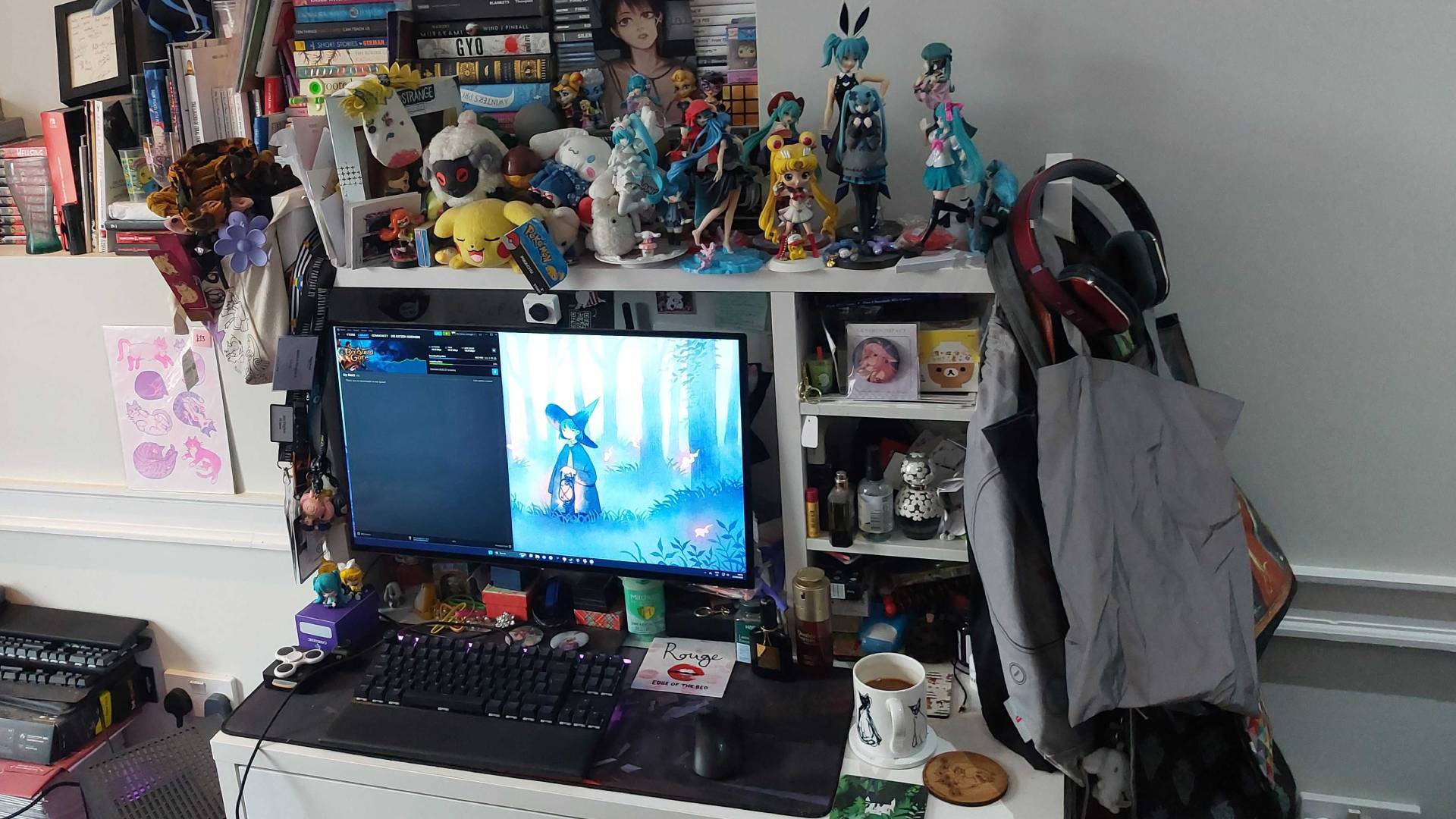 Jess Kinghorn's desk with a gaming PC, monitor, smattering of figures and plushes, plus a mug of coffee