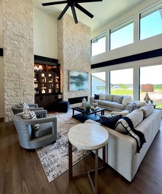 Living room with vaulted ceiling, gray couches and armchairs and blue gray abstract rug