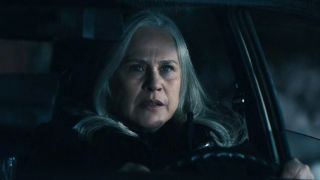 Patricia Arquette as Ms. Cobel sitting in her car with her hands on the wheel looking stressed.