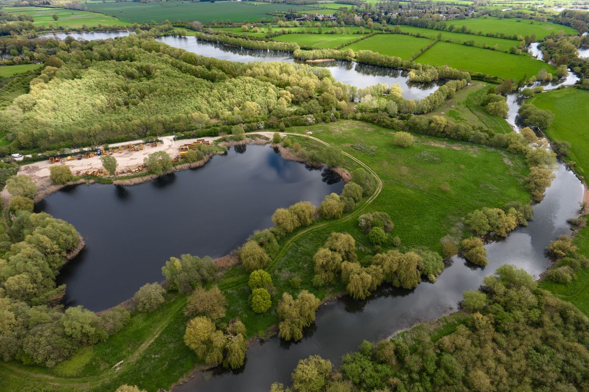 Image taken by the DJI Inspire 3 drone. Here we see an overhead view of a lake surrounded by grass and trees.