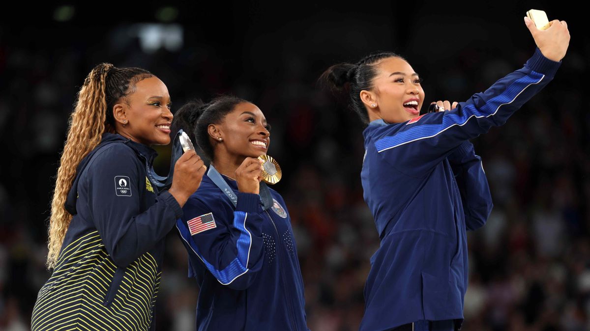 (From left) Silver medalist Rebeca Andrade of Team Brazil, gold medalist Simone Biles of Team and bronze medalist Sunisa Lee of Team USA pose for their Victory Selfie during the Artistic Gymnastics Women&#039;s All-Around Final medal ceremony. (Photo by Samsung / Getty Images