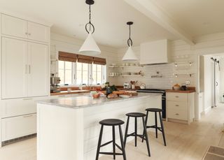 White kitchen with island and black bar stools