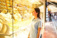 Woman looking at gold jewellery in a display case