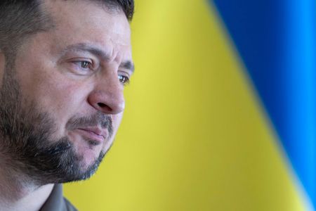 Volodymyr Zelenskyy in front of the Ukrainian flag