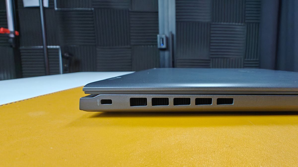 A close up of the side vents of a laptop, on top of a yellow surface