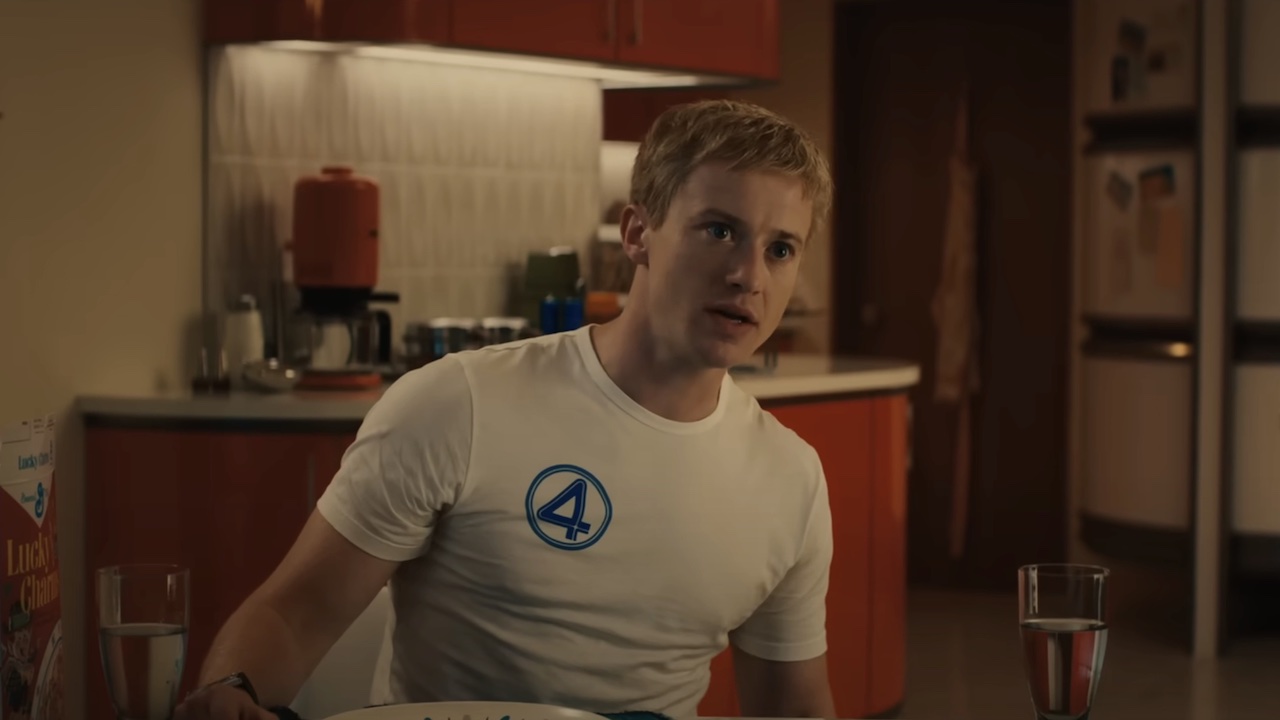 Joseph Quinn's Johnny Storm seated at dinner table in white Fantastic Four t-shirt