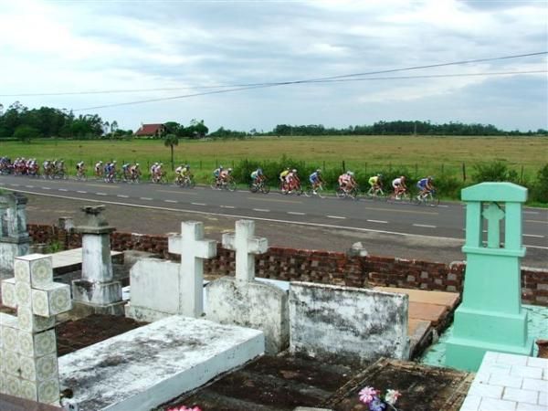 Riders pass a cemetery