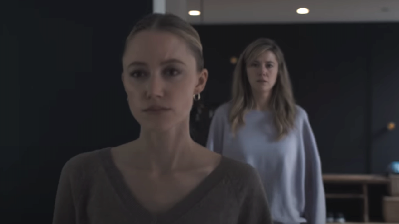 Maika Monroe walking while Mary Elizabeth Winstead walks behind her in The Hand That Rocks The Cradle