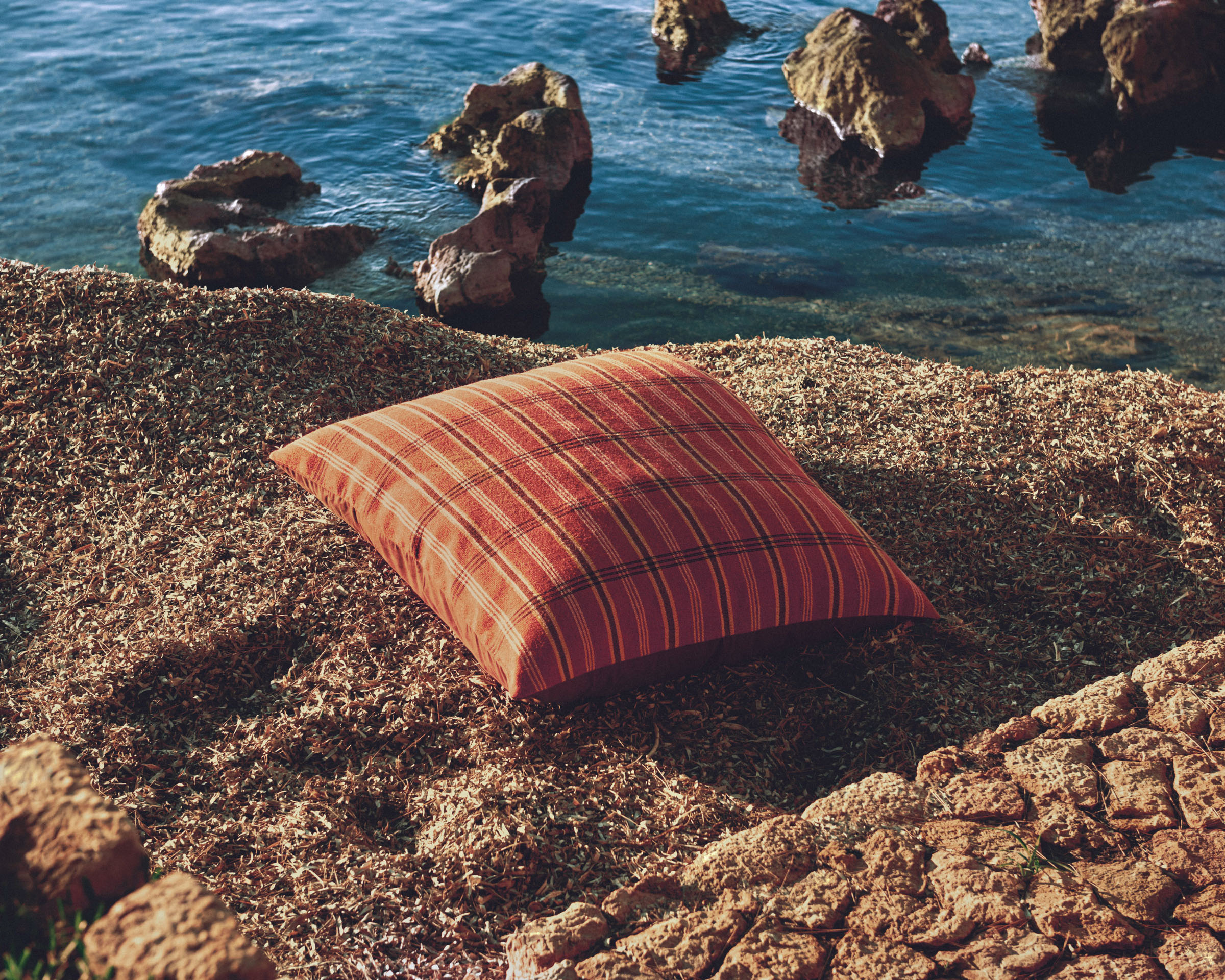 cushion on rocks next to the sea