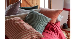 cosy bed with piles of scatter cushions to make it look cosy