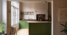 A kitchen with a wooden countertop and green island