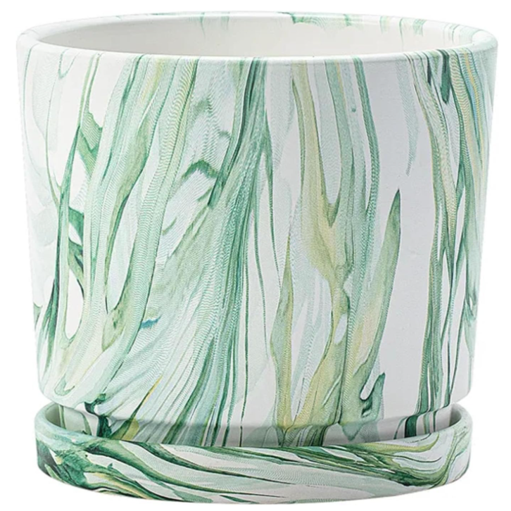 a faux marble planter which is round with green abstract paint detailing