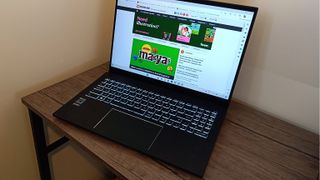 A black MSI Summit E16 Flip Evo laptop sitting on a brown wooden desk