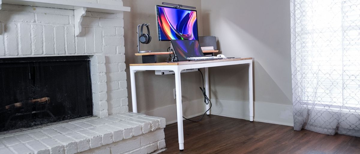 The Branch Four Leg Standing Desk set up in the corner of a living room