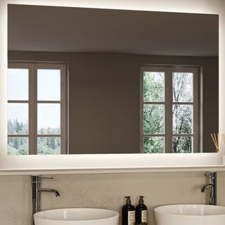 large rectangular backlit mirror above two round sinks with chrome taps