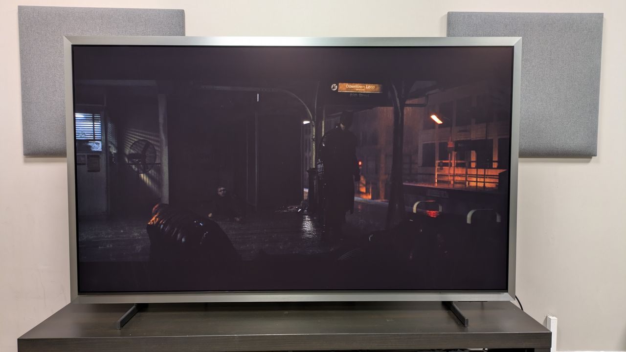 Samsung S99H with a shot of Batman on a subway platform from The Batman. The S99H is set to Filmmaker mode in a bright room and the movie is difficult to see