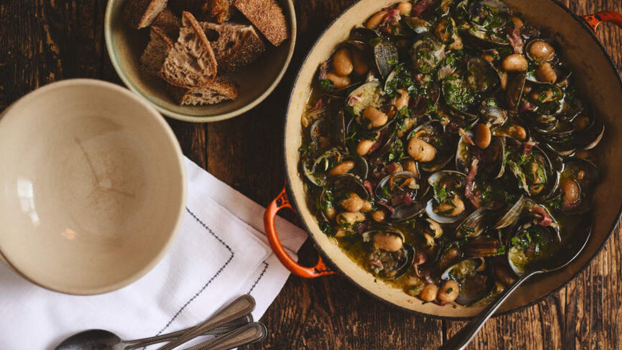 clams, butter beans and jamon in a pot