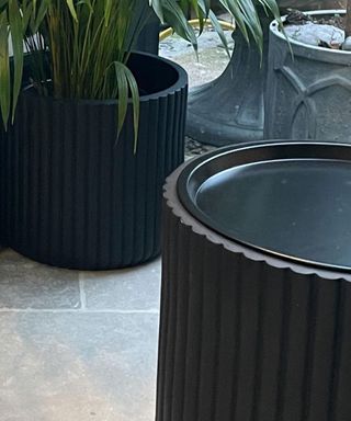 A DIY coffee table made from a large planter pot with pizza lid