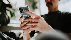 Mans hand holding a mobile phone. Conceptual with space for copy.