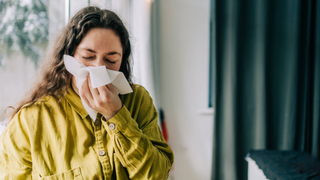 Woman blowing her nose with a tissue