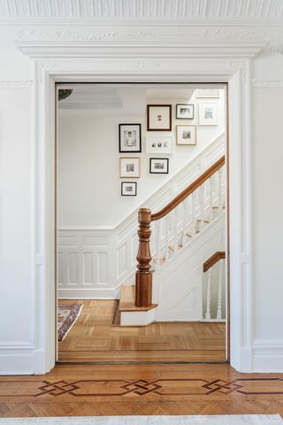 A view through a doorframe of a staircase with hanging photos along the wall