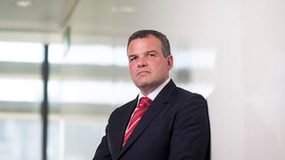 Outgoing WANdisco CEO, pictured from the waist up in a suit in a white corridor